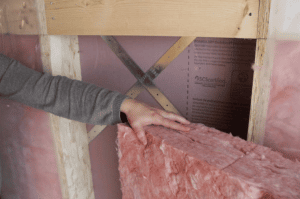 installing blocks of fiberglass insulation