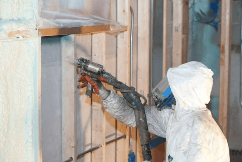 spraying insulation on a wall